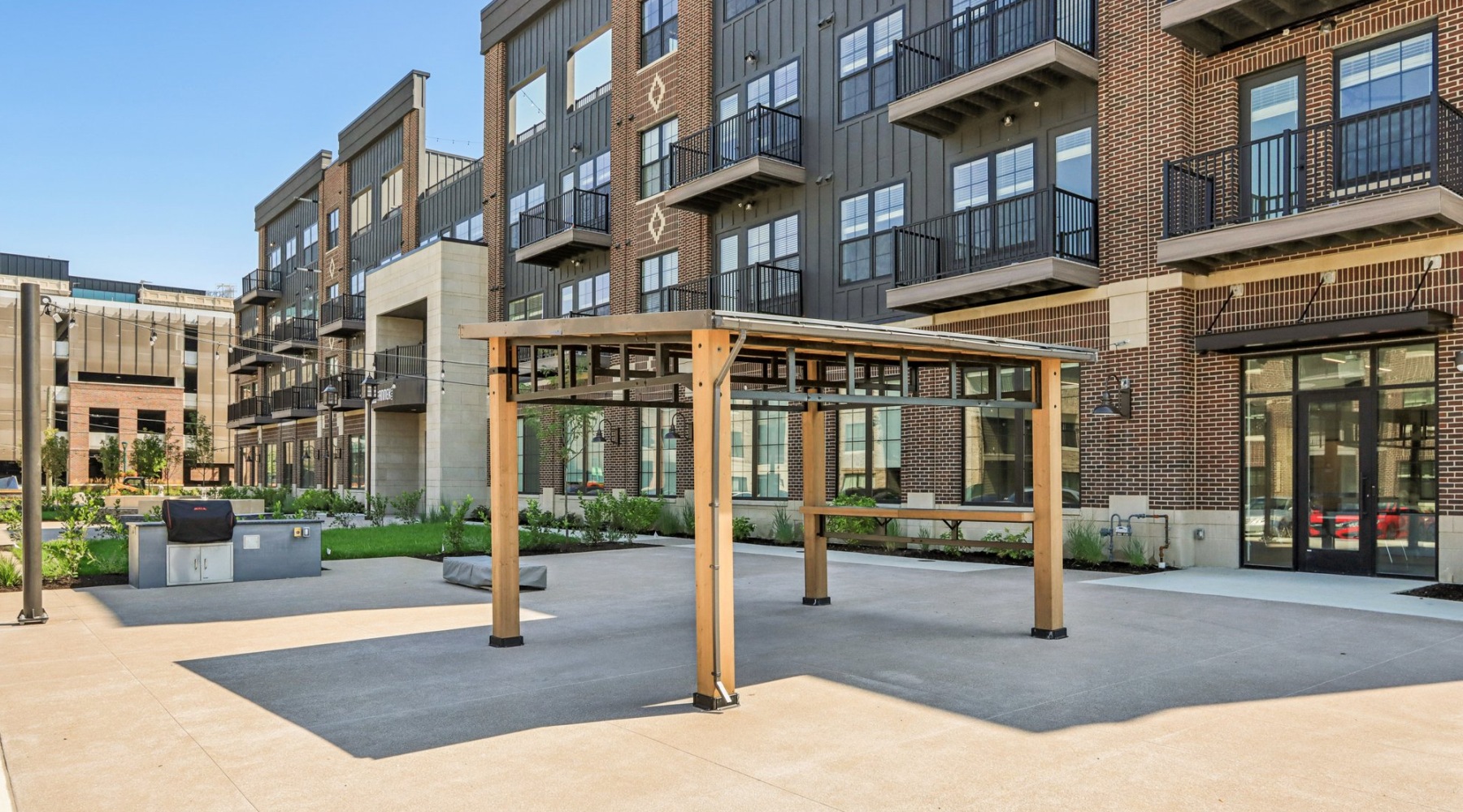 Pergola and grills in front of apartment building