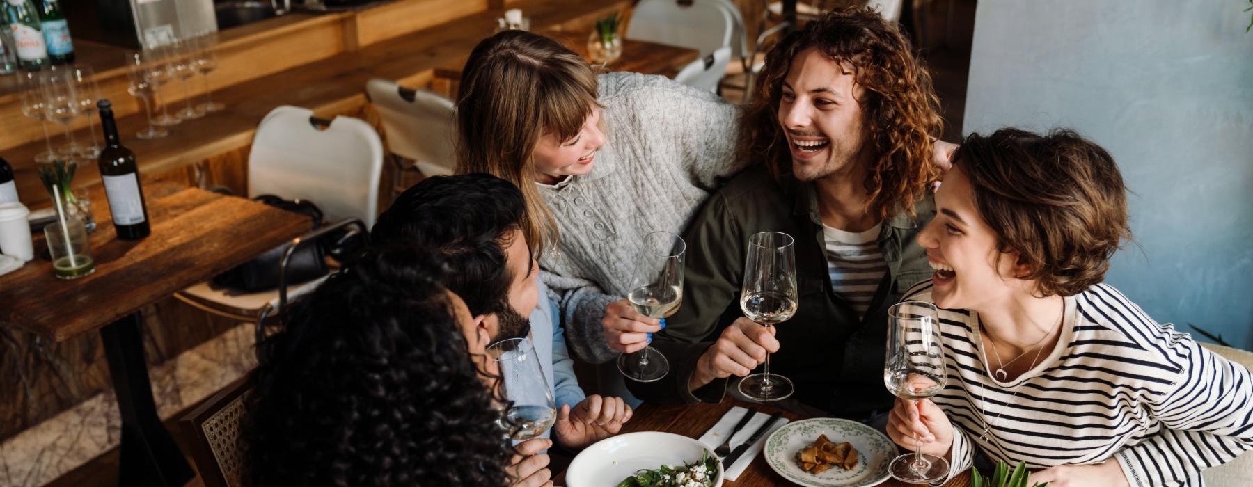 a group of people sitting around a table with food and drinks