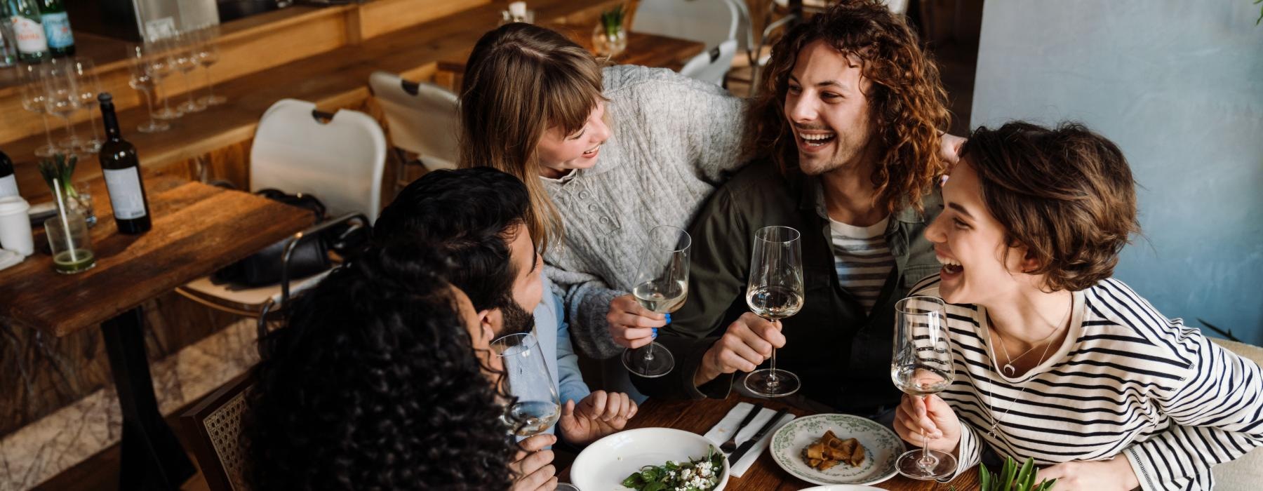 a group of people sitting around a table with food and drinks